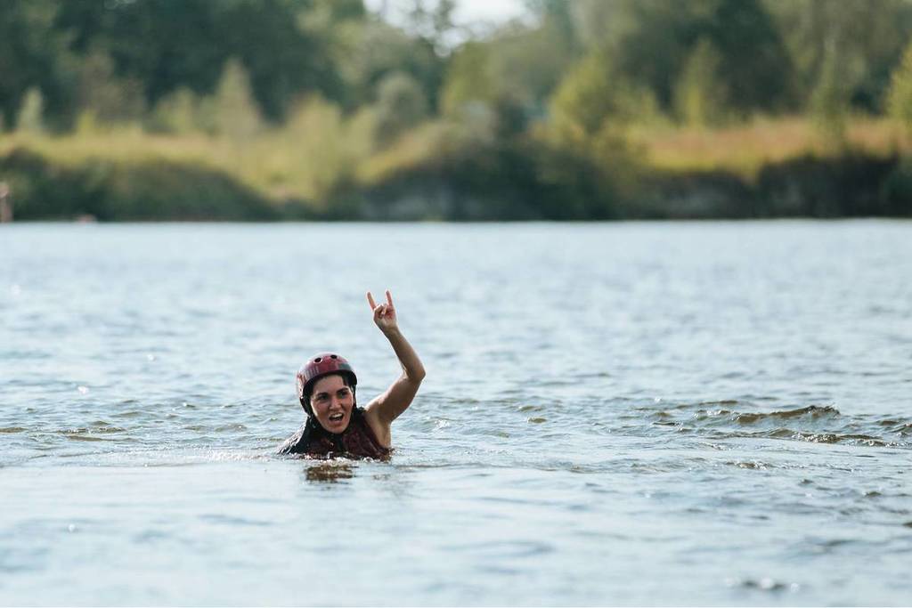 Mujer nadando en aguas abiertas en un lago con un casco rojo