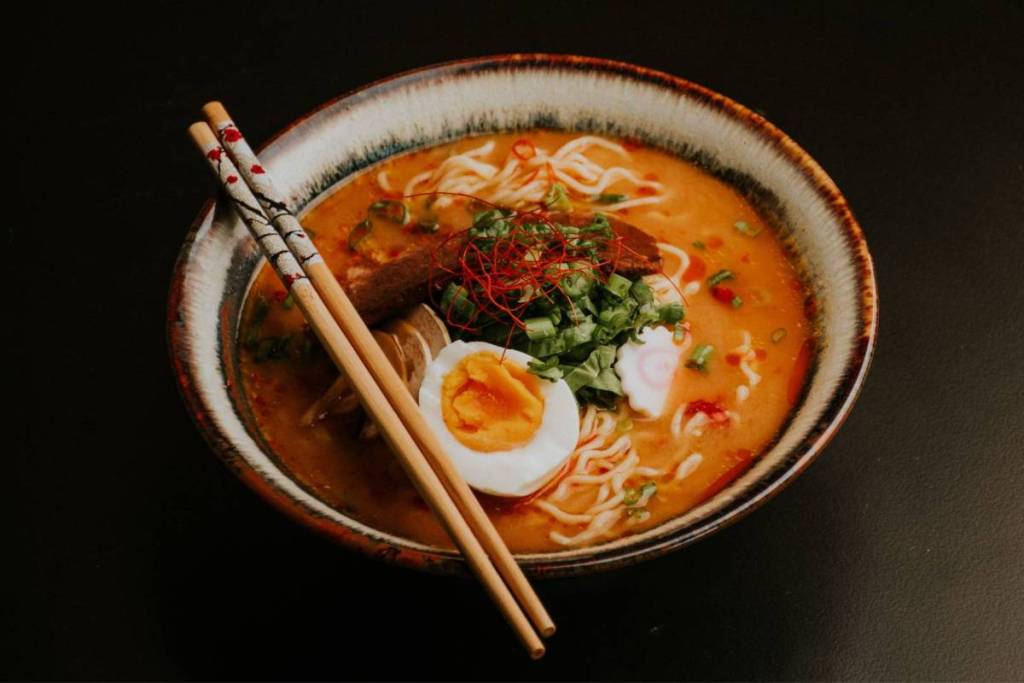 An authentic Japanese ramen dish served in a ceramic bowl with noodles, egg, and toppings. The perfect example of traditional ramen in Amsterdam for a culinary guide.