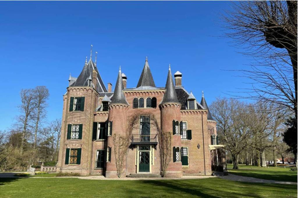 El castillo neogótico de Keukenhof, en Lisse, con sus características torrecillas y su césped verde bajo un cielo azul claro. Situado en la famosa finca de Keukenhof, en Holanda Meridional.