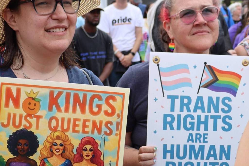 Dos manifestantes con pancartas en las que se leía «No Kings, Just Queens!» y «Trans Rights Are Human Rights» durante un acto del WorldPride en Ámsterdam.