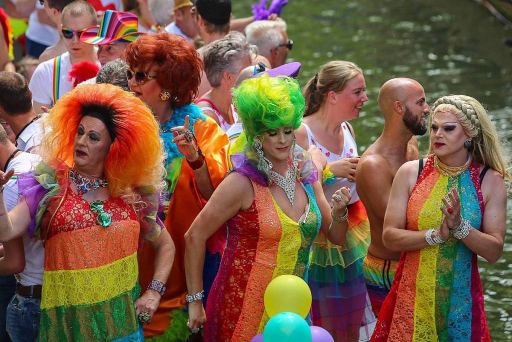 Las drag queens, con coloridos vestidos arcoíris y pelucas llamativas, bailan en un barco durante el Canal Parade por los canales de Ámsterdam.