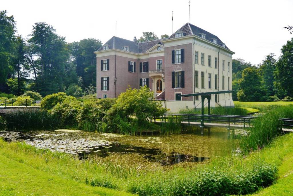 Vue de face du domaine de Huis Doorn avec son pont-levis en bois et son étang aux nénuphars sur l’Utrechtse Heuvelrug.