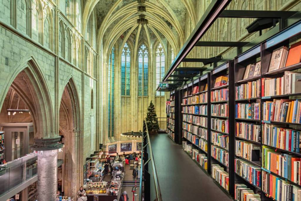View from the top floor of the black steel “book tower” of the bookshelves and the tall Gothic windows.