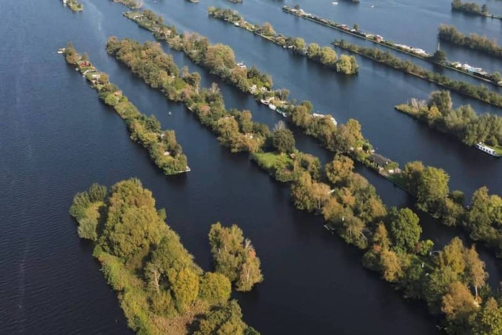Vue aérienne des plaines verdoyantes parsemées de maisons de vacances, entourées par les eaux limpides de Vinkeveen.