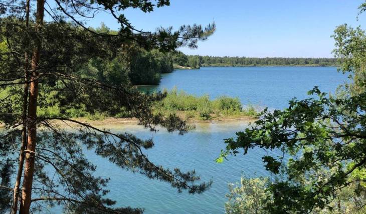 Op 2 uur van Amsterdam vind je het mooiste meer van Nederland: een 45 meter diepe zandafgraving met azuurblauw water en een iconisch trekpontje