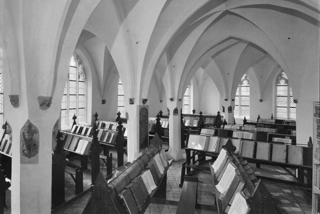 Interieur van De Librije kettingbibliotheek in de Sint-Walburgiskerk te Zutphen met vastgeketende boeken op houten lectrijnen.