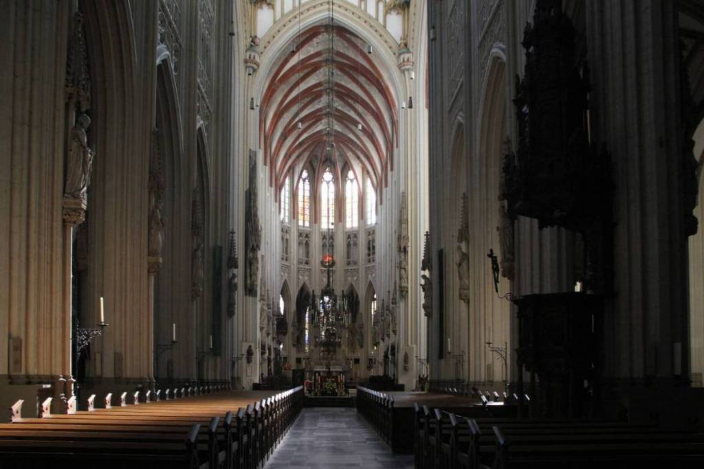 Interior de la catedral de San Juan en Den Bosch, con la elevada nave central, la bóveda de crucería y los bancos de madera.