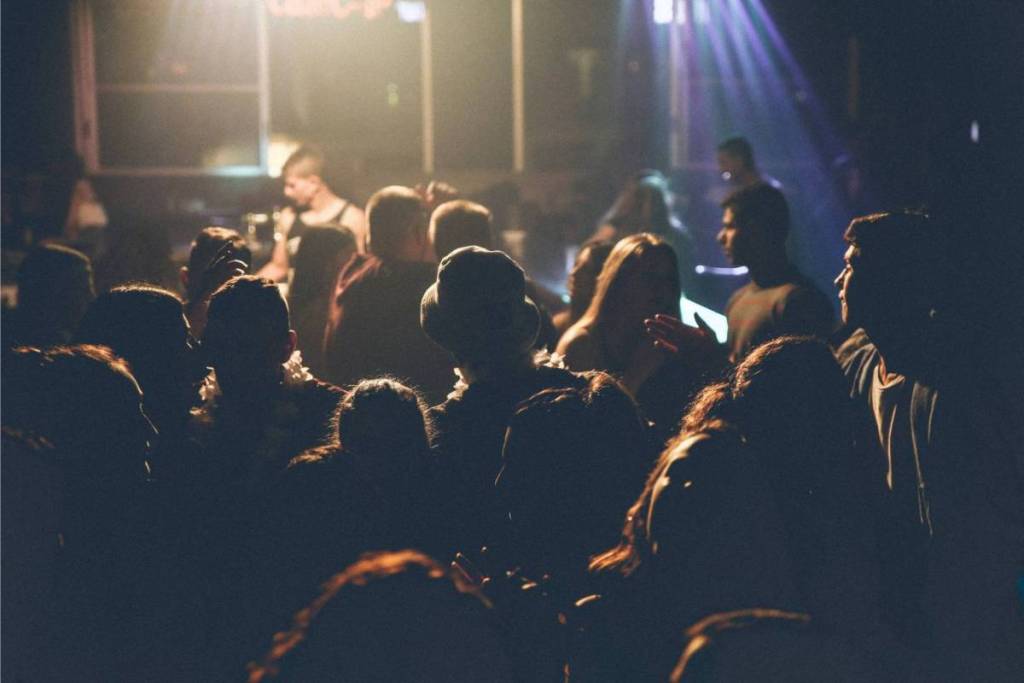 Una serata da discoteca piena di atmosfera con una folla che balla sotto le luci colorate del palco.
