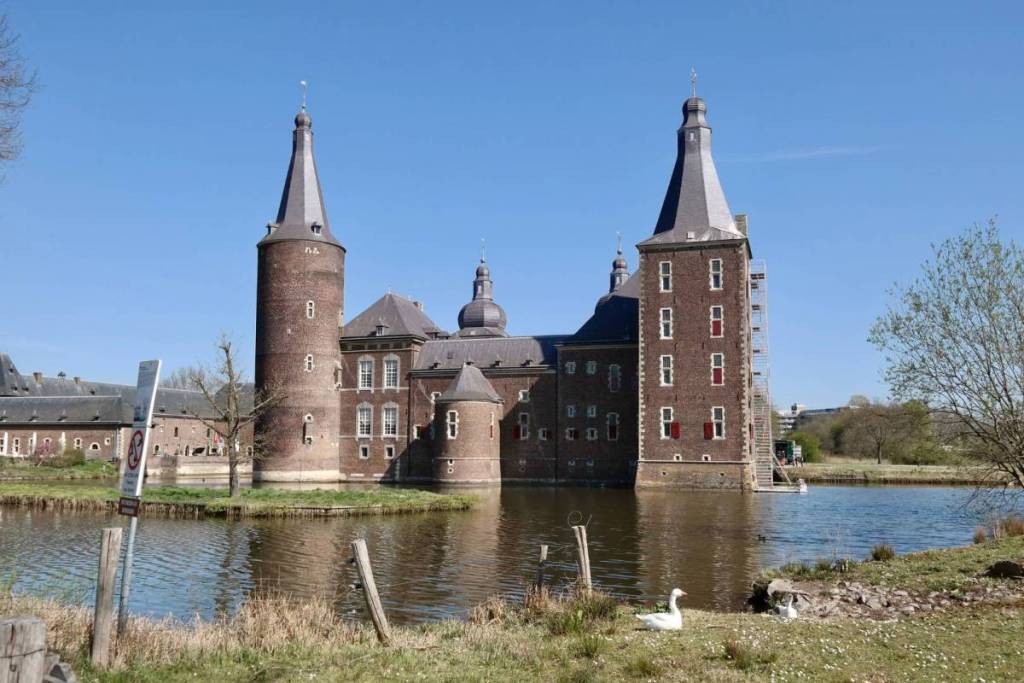 Fachada de ladrillo del castillo de Hoensbroek, en el sur de Limburgo, con la torre redonda de la residencia y su reflejo en el foso
