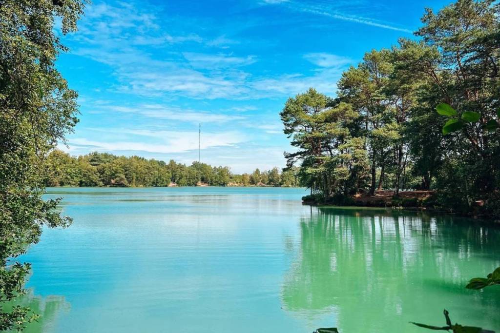 Acqua blu intenso del Lago Blu con il riflesso degli alti pini in una soleggiata giornata estiva.