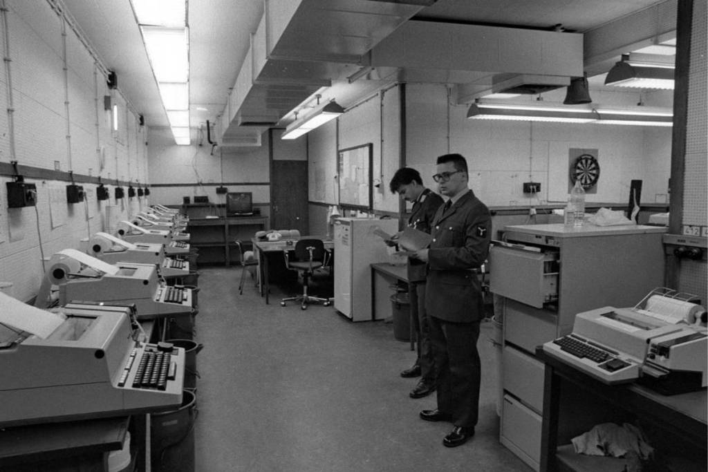 Photo en noir et blanc de militaires et d’équipements de télécommunication au quartier général souterrain de l’OTAN, dans le Cannerberg.