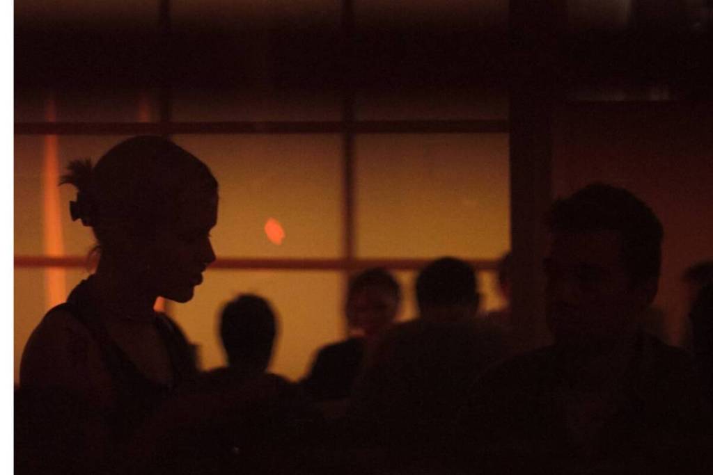 Guests in the cozy, warmly lit interior of the Corner Store listening bar in Amsterdam-Noord.