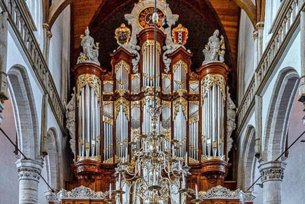 El órgano principal histórico de la Oude Kerk de Ámsterdam, con detalles dorados y tallas de madera.