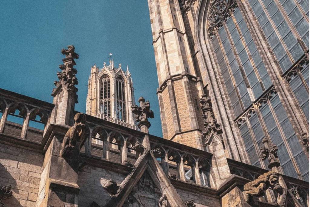 Vista detallada de los arcos góticos y la alta torre de la catedral de Utrecht.