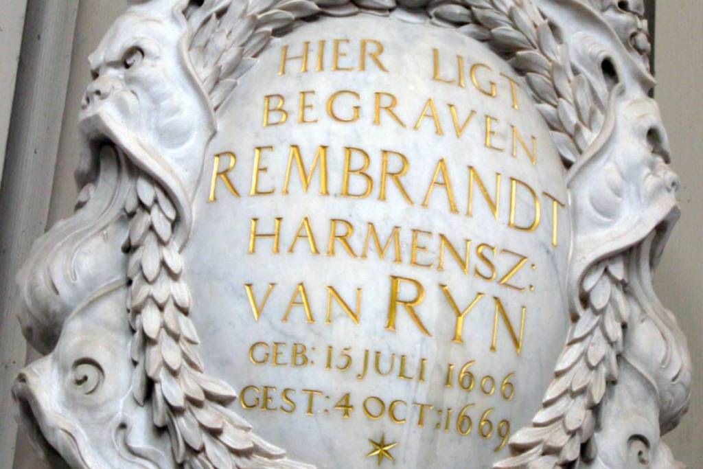 Placa conmemorativa de mármol con inscripción dorada dedicada a Rembrandt van Rijn en la Westerkerk de Ámsterdam.