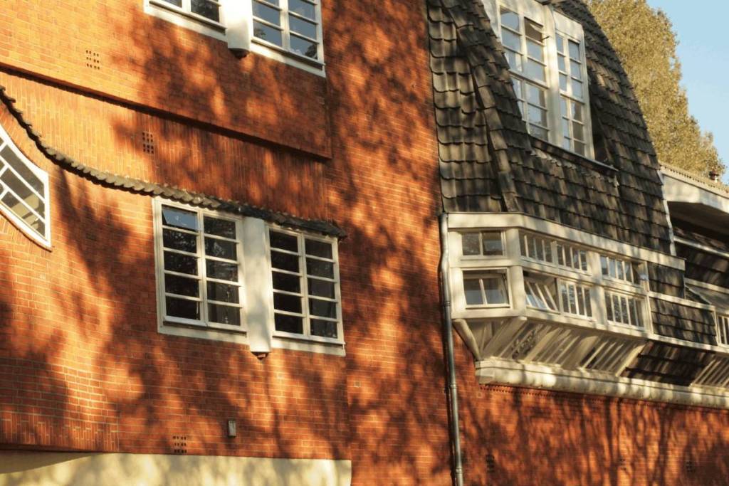 Detail van de oranje bakstenen gevel en houten kozijnen van Het Schip in de stijl van de Amsterdamse School.