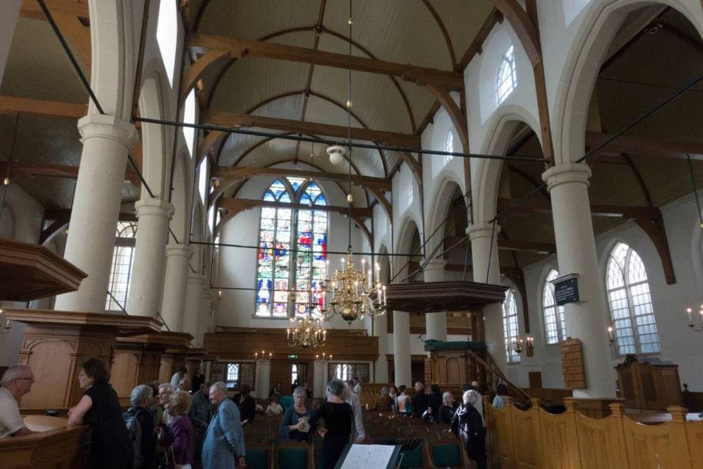 Interior de la Iglesia Valona con púlpito, vigas de madera y vidriera