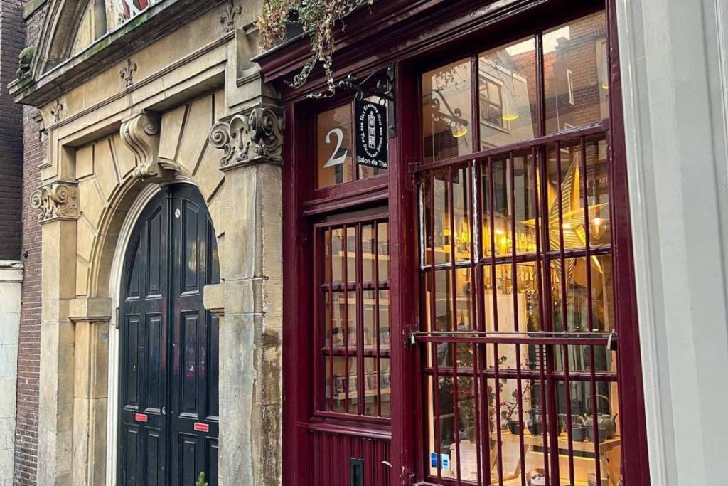 Fachada de la tetería más pequeña de Ámsterdam, en el número 22, con vistas al marco de la ventana y a la puerta de salida de la Iglesia Valona.