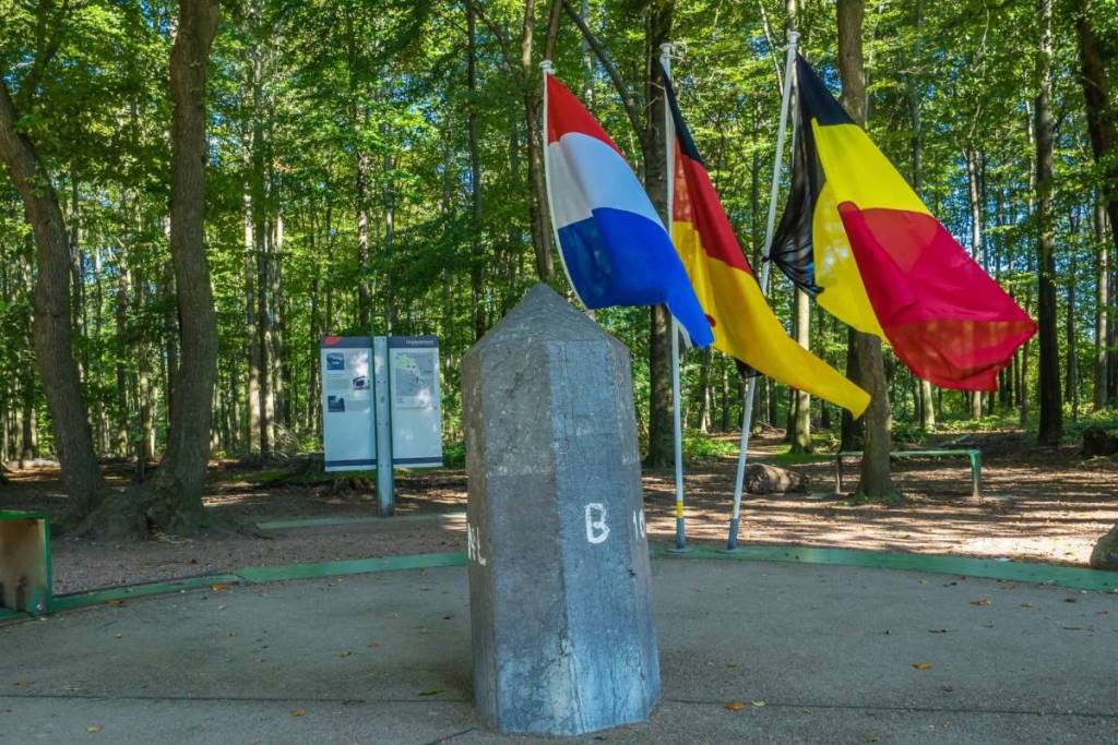 La histórica piedra fronteriza en el Punto de las Tres Naciones con las banderas de los Países Bajos, Bélgica y Alemania.