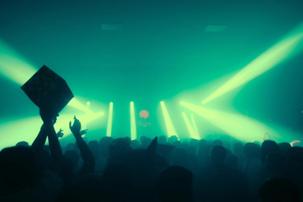 Een volle dansvloer in een Amsterdams club met felle groene laserstralen door de rook.