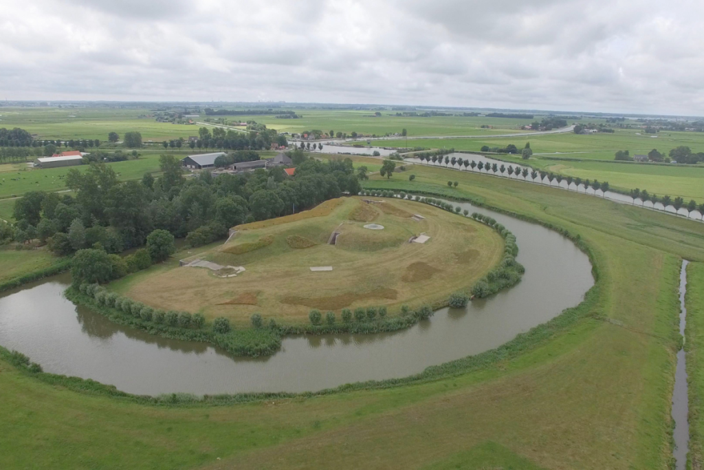 Luftaufnahme einer kreisförmigen, grünen Festungsinsel im Beemster-Polder, umgeben von einem Wasserweg.