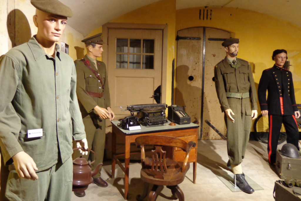 Ausstellung im Inneren des Forts bei Spijkerboor mit Schaufensterpuppen in historischen Militäruniformen und einem alten Schreibtisch.