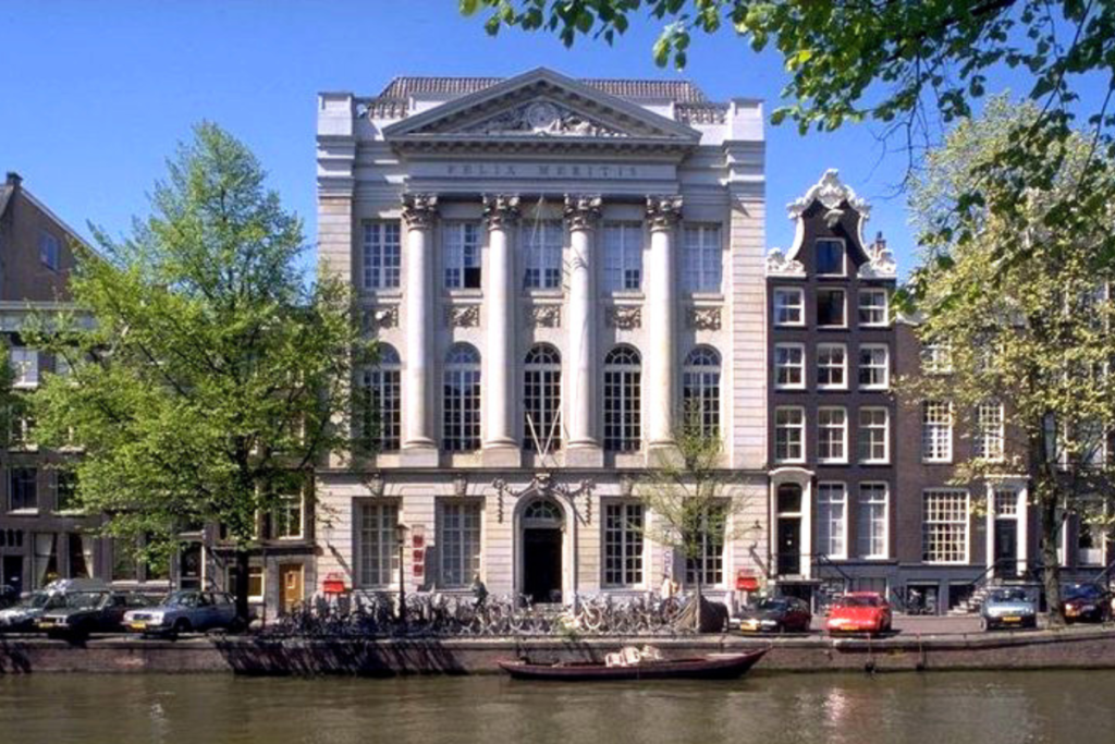 Die imposante Fassade von Felix Meritis an der Amsterdamer Gracht, mit Bäumen und geparkten Fahrrädern.