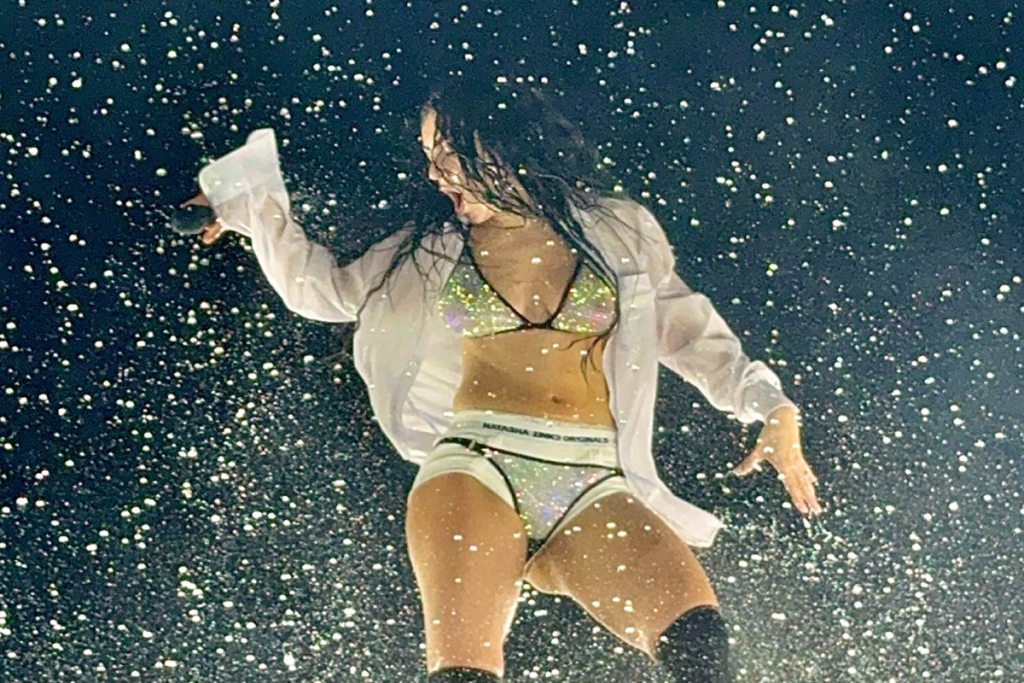 Charli XCX tritt während ihres Live-Konzerts in einem glitzernden Outfit auf der Bühne auf