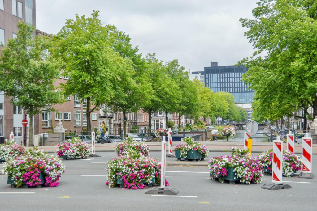 Barrières de circulation temporaires avec des bacs à fleurs et des poteaux rouges et blancs sur la Weesperstraat rétrécie à Amsterdam