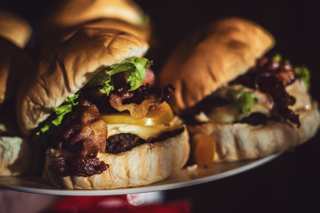 Handwerklich zubereiteter Burger mit knusprigem Speck, geschmolzenem Käse und frischen Zutaten auf einem weichen Brötchen.