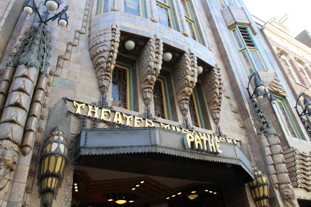 Detaillierte Fassade des Königlichen Theaters Tuschinski in Amsterdam mit dekorativen Skulpturen und Laternen im Stil der Amsterdamer Schule.
