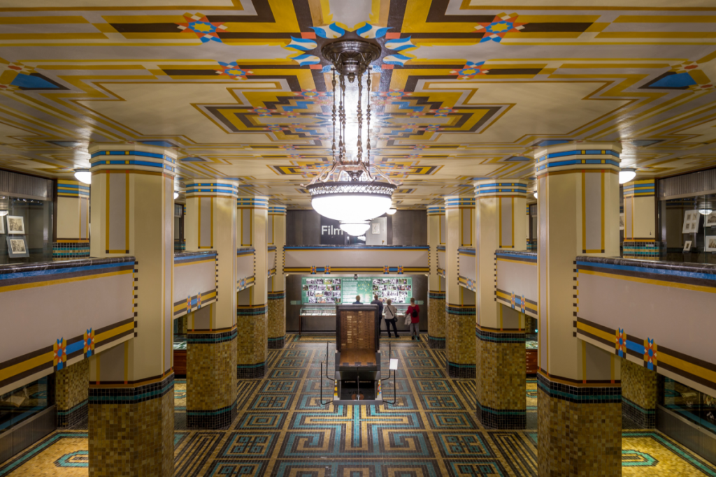Die beeindruckende Schatzkammer im Gebäude „De Bazel“ des Amsterdamer Stadtarchivs mit farbenfroher Art-déco-Architektur und kunstvollen Deckenmotiven.