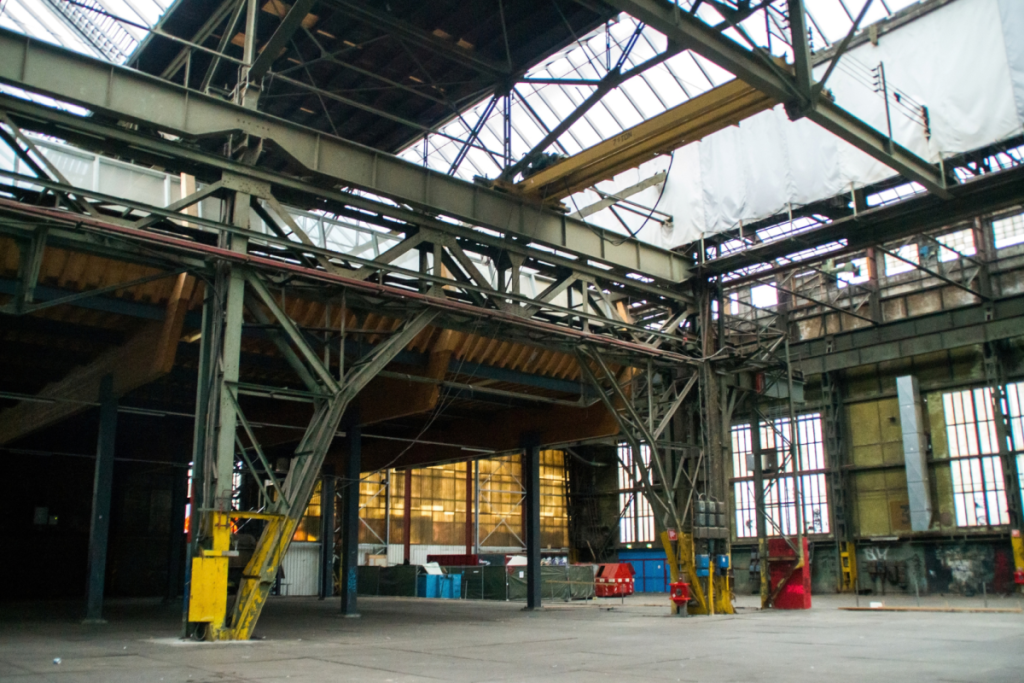 Das industrielle Stahlskelett und der rohe Innenraum der denkmalgeschützten NDSM-Halle in Amsterdam-Nord.