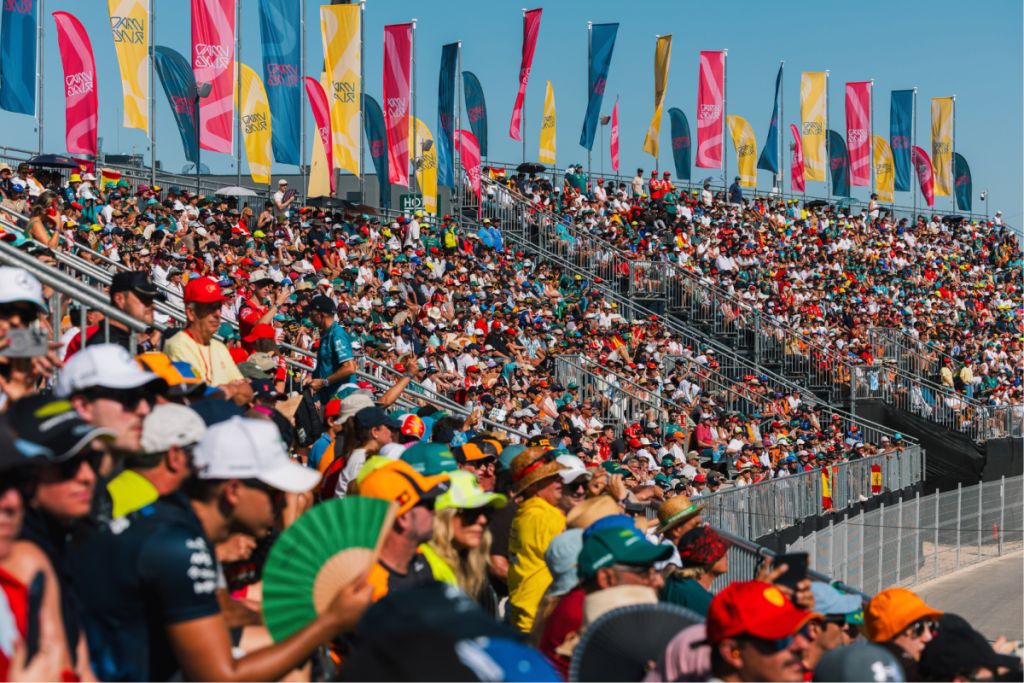 Eine vollbesetzte Tribüne mit F1-Fans und bunten Fahnen beim Madring-Event 2026 in Madrid.