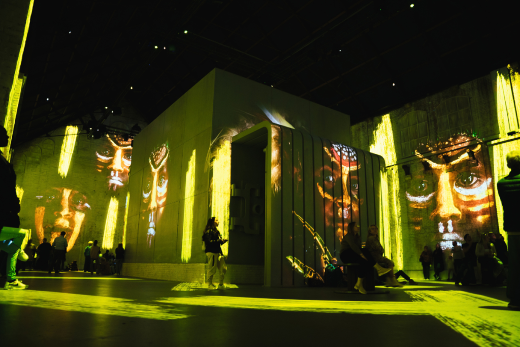 Des projections géantes de portraits aux tons jaunes et dorés du photographe Jimmy Nelson sur les murs de la Fabrique des Lumières.