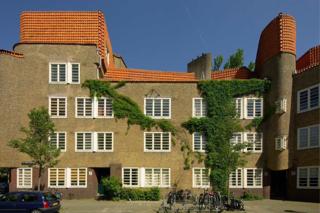 Die wellenförmige Fassade und die orangefarbenen Dachziegel des Wohnkomplexes „De Dageraad“ im Stil der Amsterdamer Schule