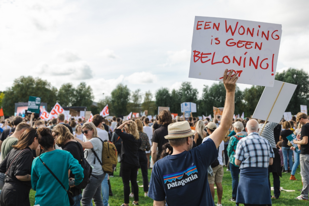 Ein Demonstrant hält bei einer massiven Wohnprotestaktion ein Schild mit der Aufschrift „Eine Wohnung ist keine Belohnung“ hoch.