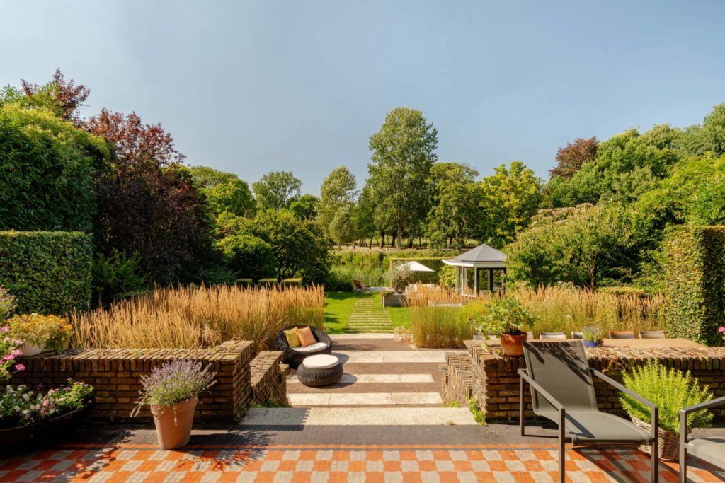 Blick vom Haus und von der Terrasse auf den grünen Hintergarten, das hölzerne Teehaus und den Vondelpark.