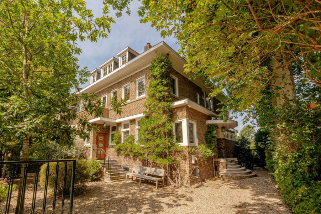 Charakteristische Backsteinfassade der freistehenden Villa an der Oranje Nassaulaan mit Auffahrt und Grünflächen.