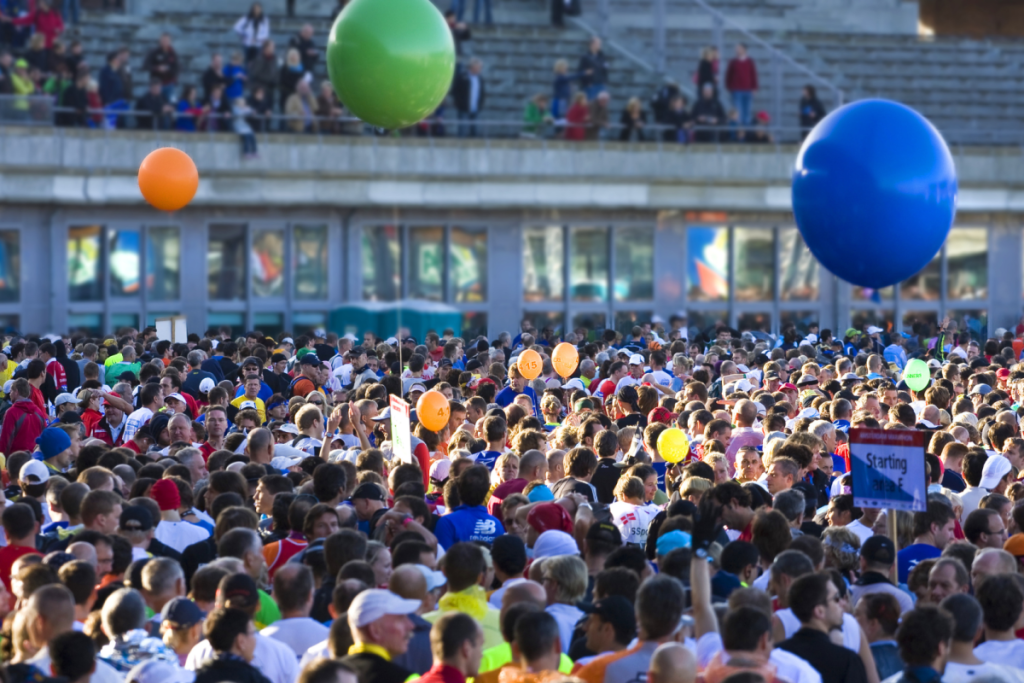 Eine große Menge von Läufern und Zuschauern versammelt sich während des Amsterdam-Marathons mit großen bunten Luftballons am Olympiastadion.