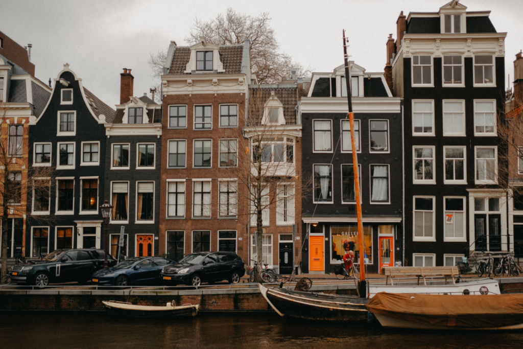 Charakteristische historische Grachtenhäuser und Hausboote am Wasser in Amsterdam.