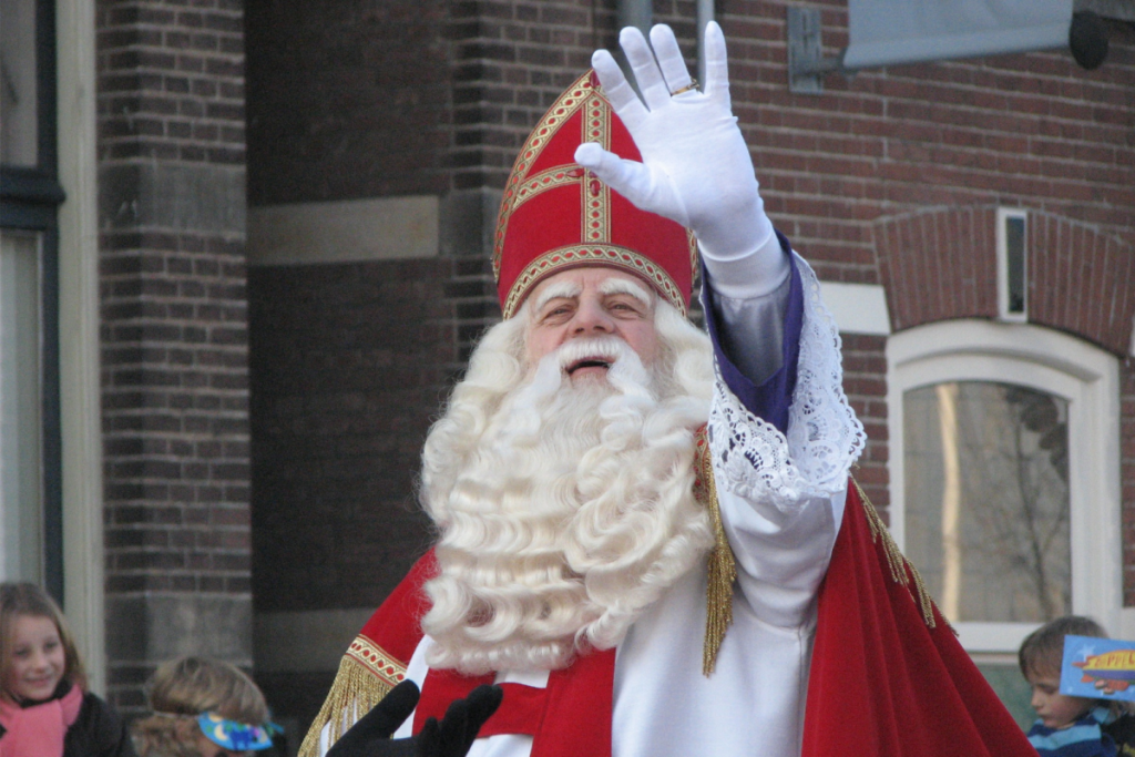 winkt der Nikolaus in seiner traditionellen roten Mitra und seinem Mantel den Zuschauern während des Einzugs fröhlich mit seiner weißbehandschuhten Hand zu.