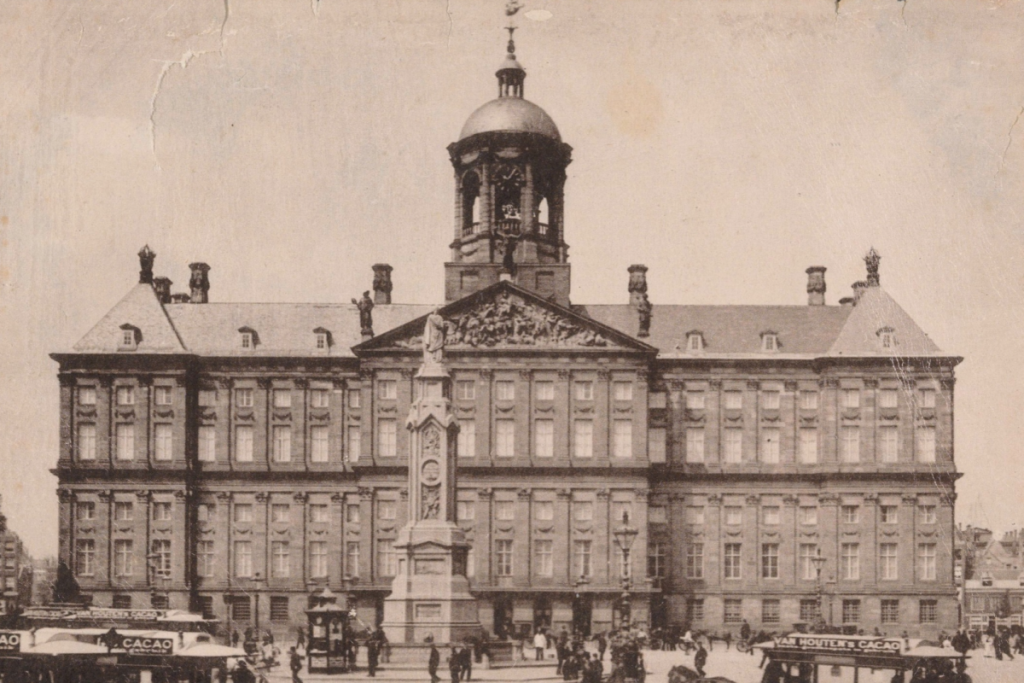Historisches Schwarz-Weiß-Foto des imposanten Palasts auf dem Dam am belebten Dam in Amsterdam.