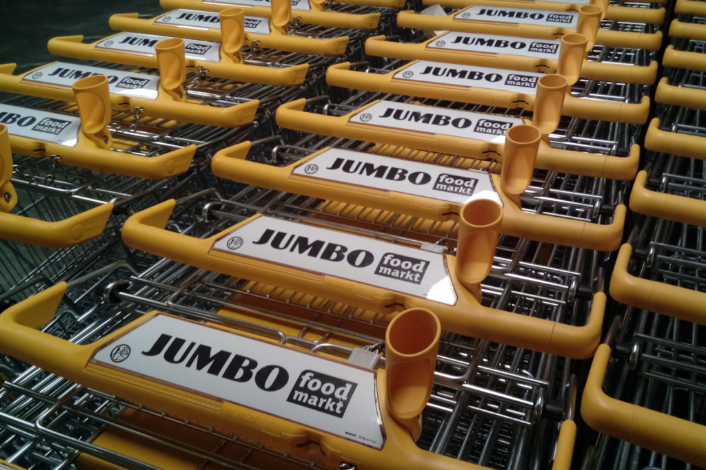 In Reihen aufgestellte gelbe Jumbo-Foodmarkt-Einkaufswagen am Eingang des Supermarkts.