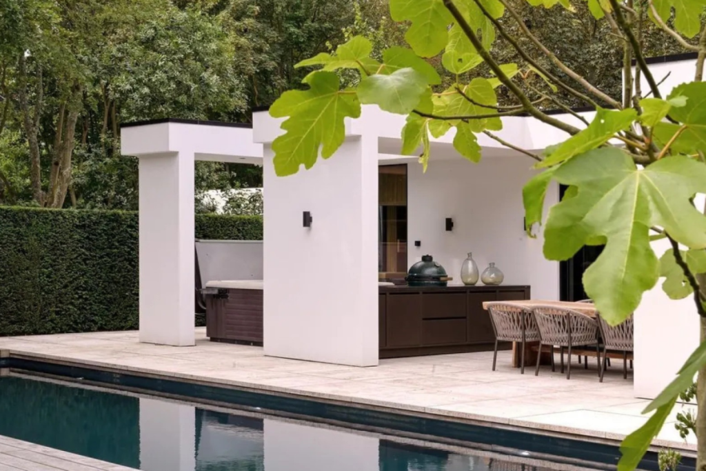 Achtertuin van de villa van Dirk Kuijt in Noordwijk met een verwarmd zwembad, jacuzzi en overdekte buitenkeuken inclusief Big Green Egg