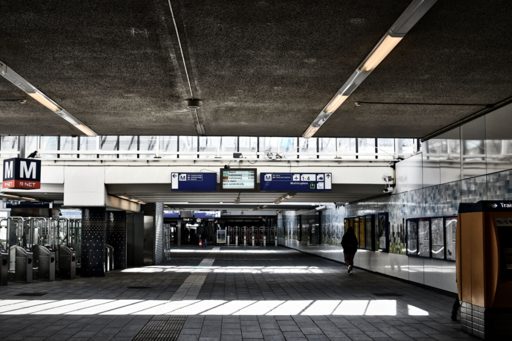 Leere Minerva-Passage am Bahnhof Amsterdam Zuid mit Check-in-Schranken und Beschilderung kurz vor dem Umbau