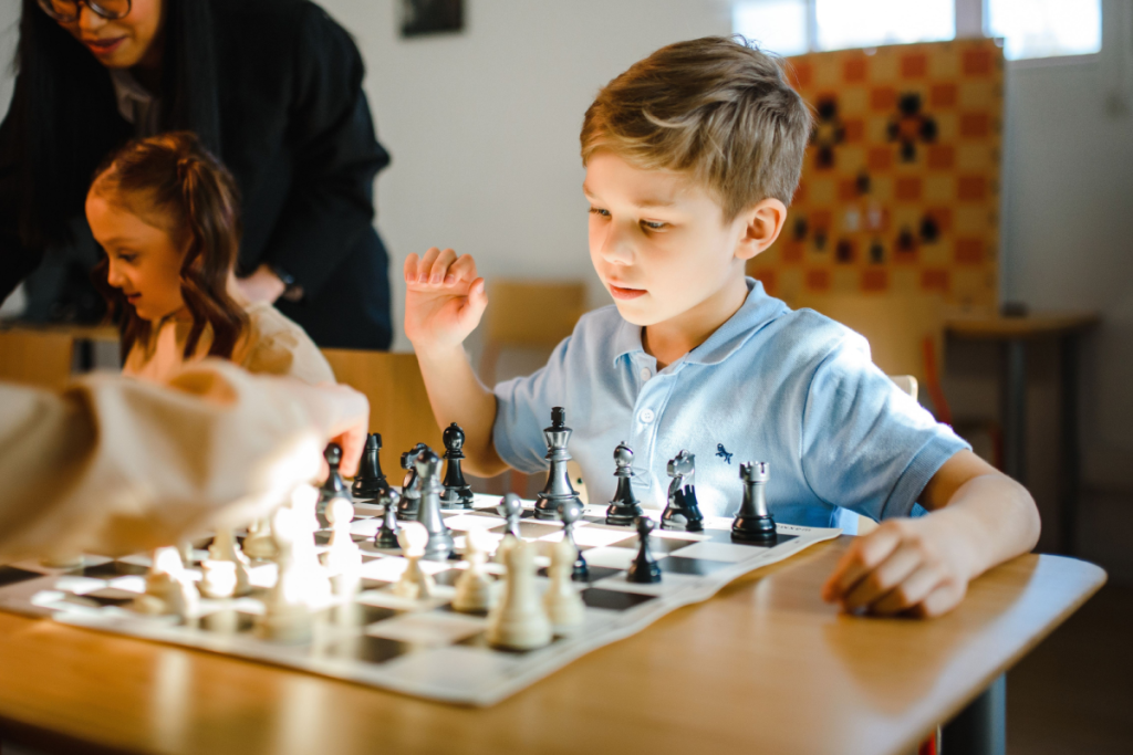 Ein Kind spielt konzentriert Schach an einem Tisch während eines Schachturniers