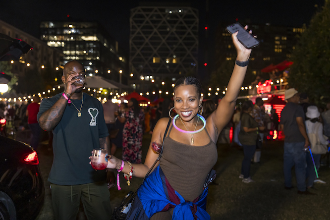 woman dancing in front of the Atlanta food and wine festival tasting tents