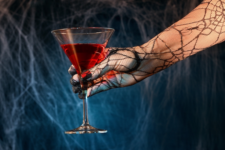 a hand holding a fancy red drink