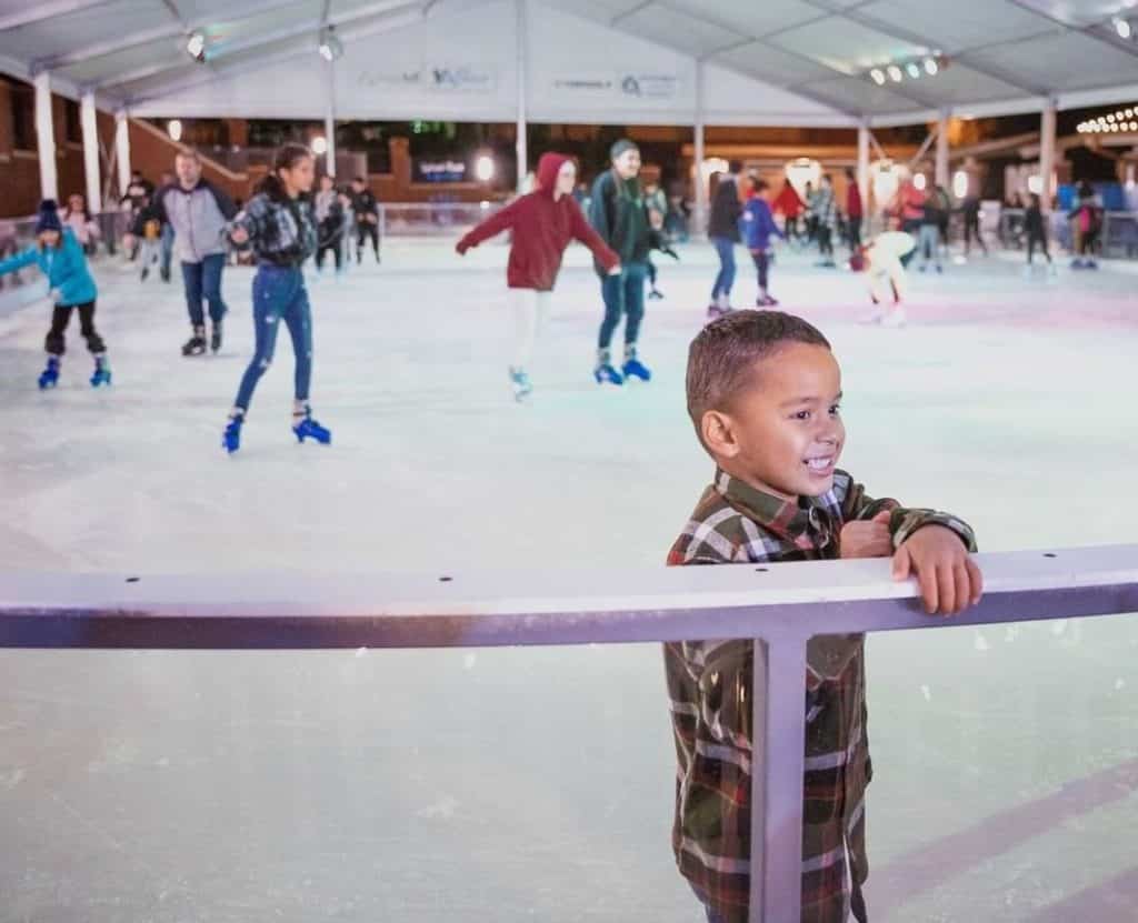 niño en una pista de patinaje sobre hielo
